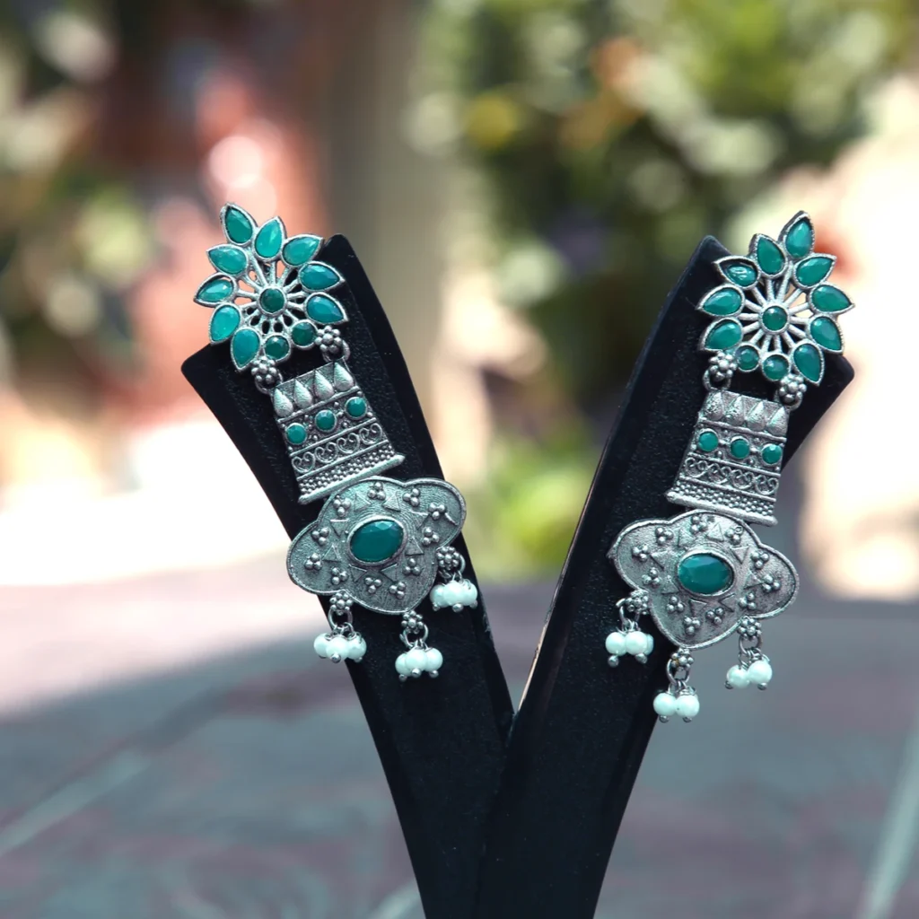Traditional emerald green stone tribal drop earrings with pearl danglings and oxidised silver finish